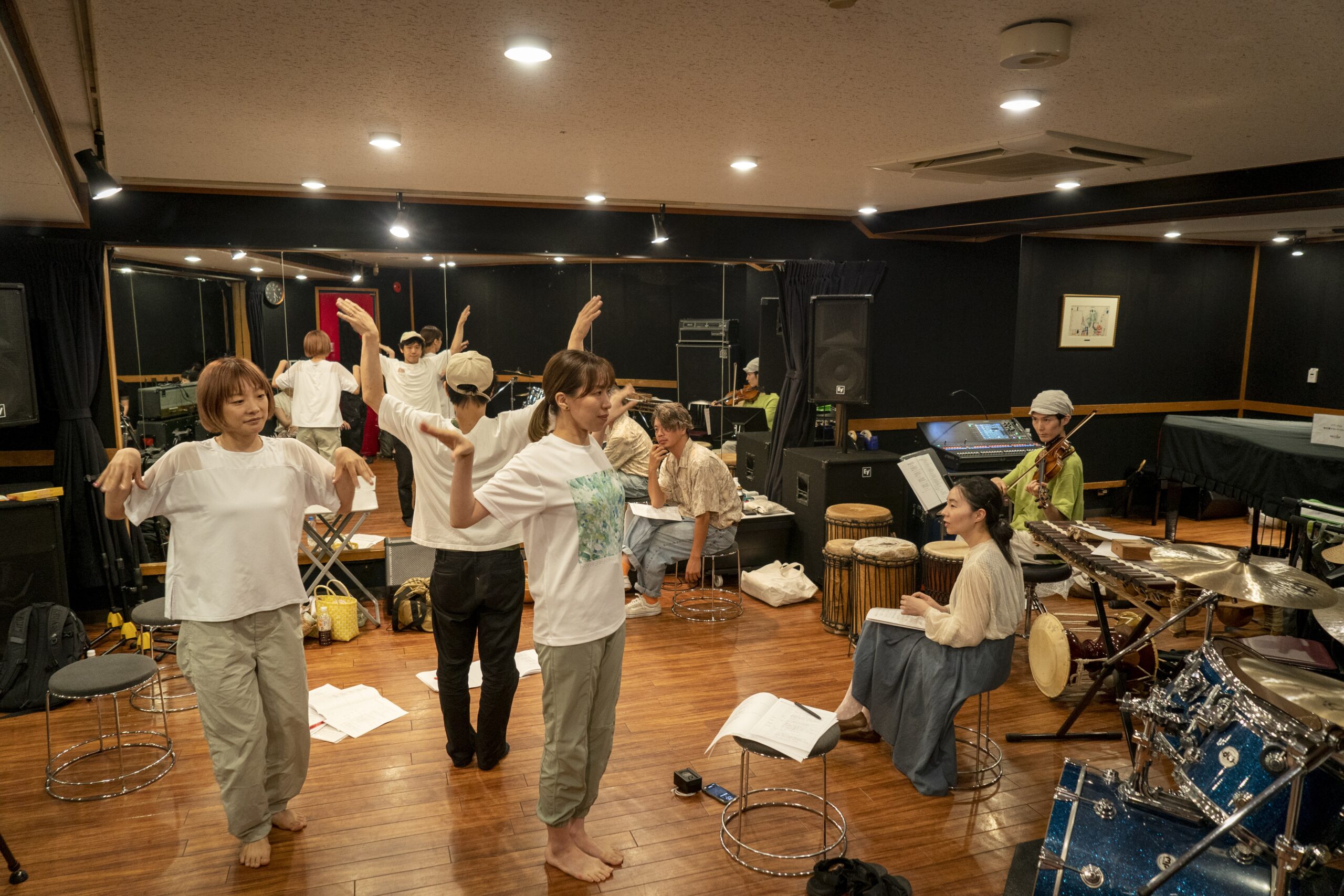 神奈川県あそび歌プロジェクト「世界の歌とあそぼう」稽古時の写真。出演者は鳥の翼のようにして両手を上げている。