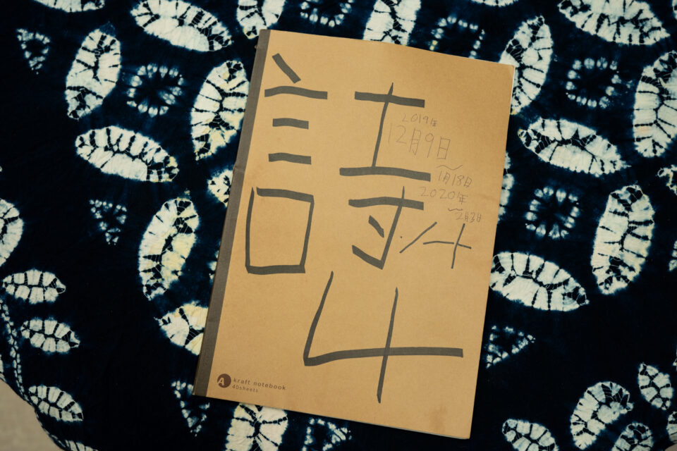 取材当日、コミュニティスペースでくつろいでいた青年のノートの写真。詩を書き溜めているという青年のノートの表紙には、「詩ノート４」と大きく書かれ、4冊目であることが伺える。「2019年12月9日～2020年2月3日」とも書かれている。